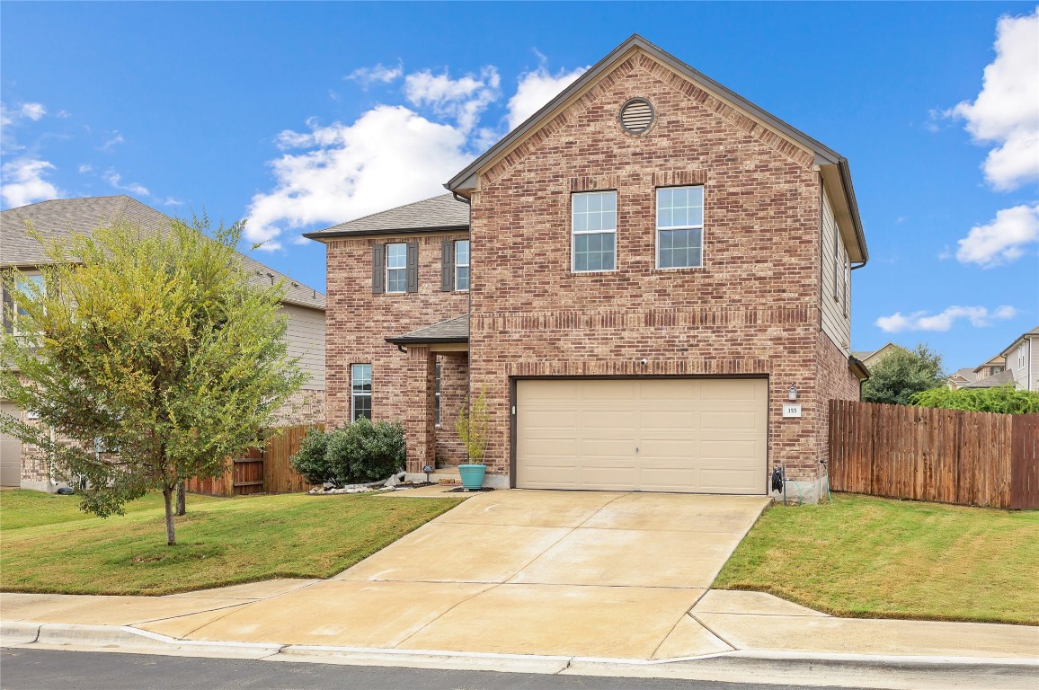 Traditional-style house with brick siding, driveway, and an attached garage