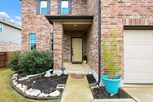 a view of a brick house with potted plants