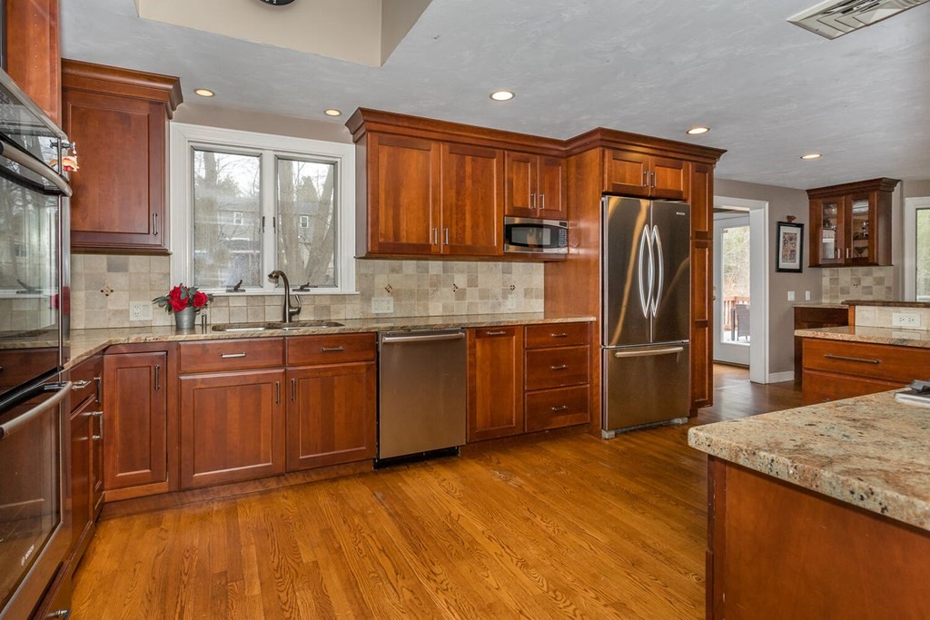 14 Kings Road Canton, MA 02021 - Photo 11 of 23 a kitchen with stainless steel appliances granite countertop a refrigerator a sink dishwasher a stove with wooden cabinets and floor