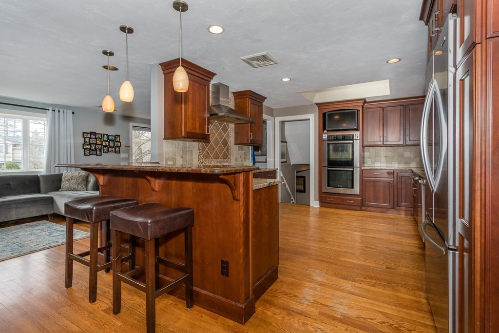 14 Kings Road Canton, MA 02021 - Photo 8 of 23 a kitchen with stainless steel appliances granite countertop dining table chairs and a refrigerator