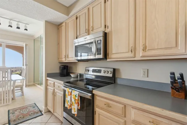 a kitchen with stainless steel appliances granite countertop a stove a sink and a white cabinets