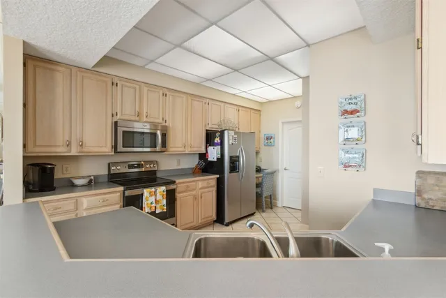 a kitchen that has a lot of cabinets a sink and appliances