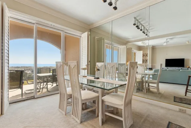 a dining room with furniture water view and a floor to ceiling window