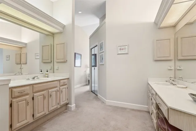 a spacious bathroom with a double vanity sink a large mirror and a bathtub