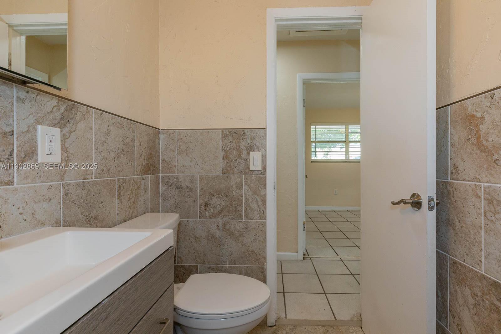 1010 North 69th Way Hollywood, FL 33024 - Photo 15 of 23 a bathroom with a toilet a sink a shower and vanity