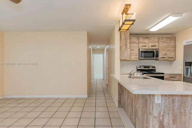a kitchen with stainless steel appliances a refrigerator sink and microwave