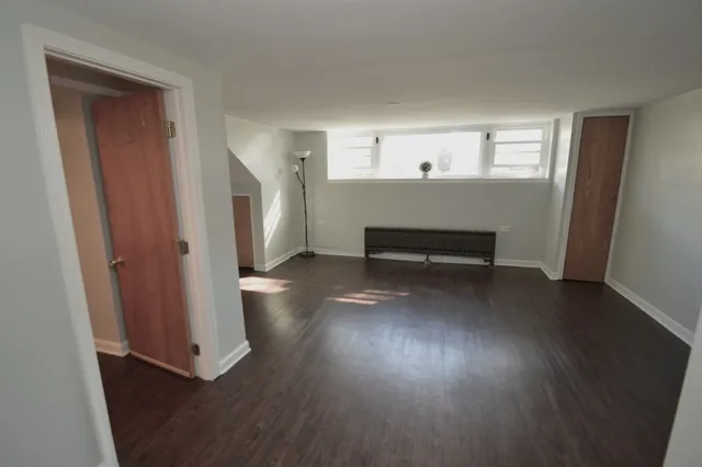 a view of a room with wooden floor and window