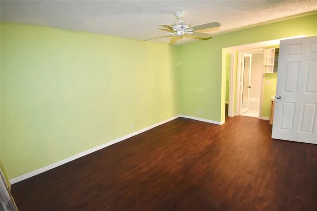 a view of a big room with wooden floor and entryway