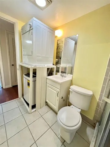 a white toilet sitting next to a bathroom sink and vanity