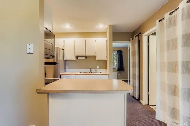 a large kitchen with a large counter top stainless steel appliances and cabinets