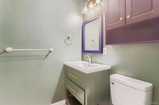 a bathroom with a sink a toilet and mirror