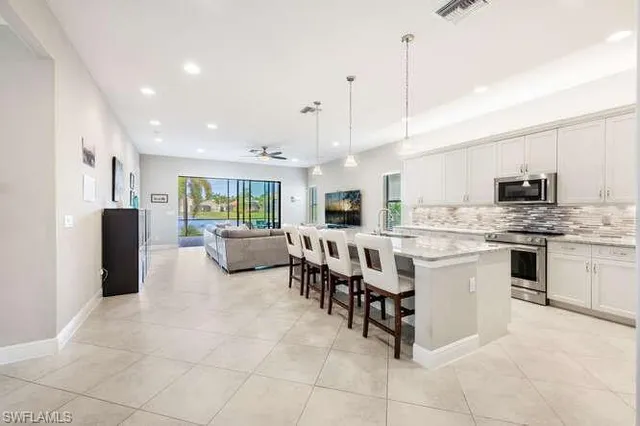 a large white kitchen with lots of counter space and furniture