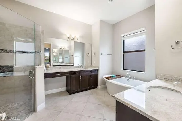 a large bathroom with a granite countertop sink a toilet a mirror and bathtub