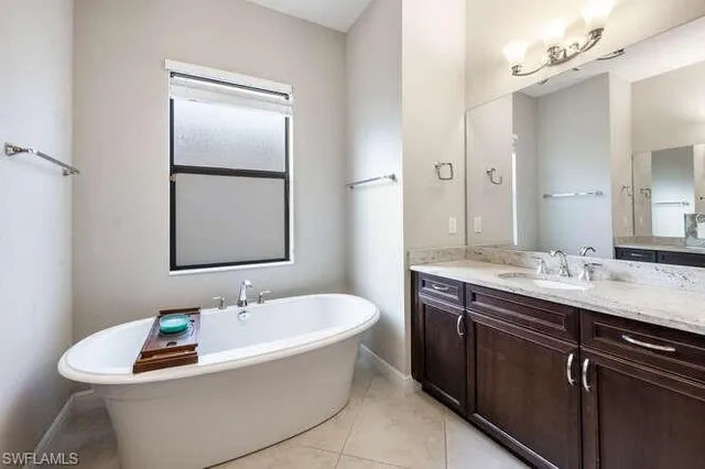 a bathroom with a tub a sink and mirror