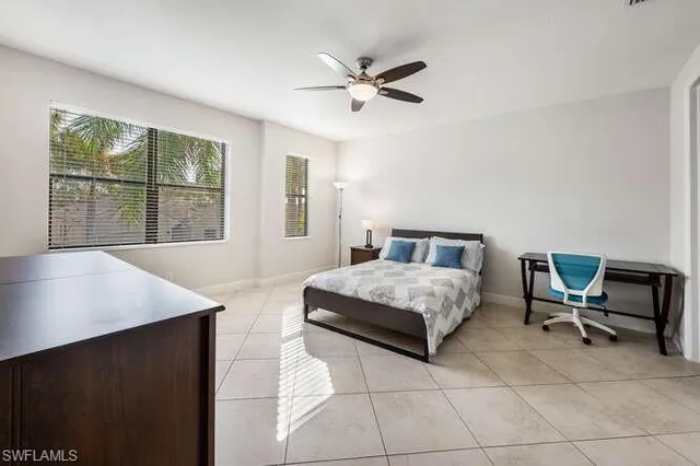 a bedroom with a bed a table and a large window