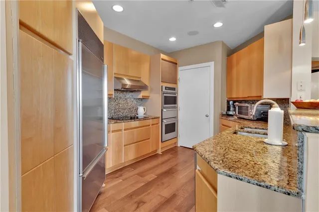 a kitchen with stainless steel appliances granite countertop a sink and cabinets