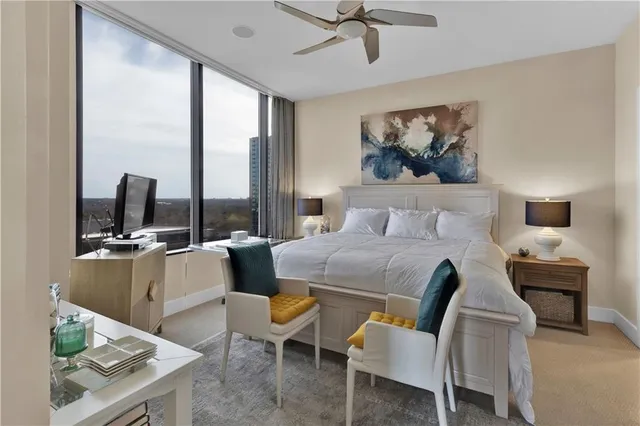 a bedroom with a bed a large window and table