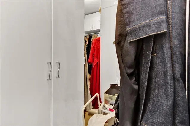 a view of walk in closet with clothes and shoes