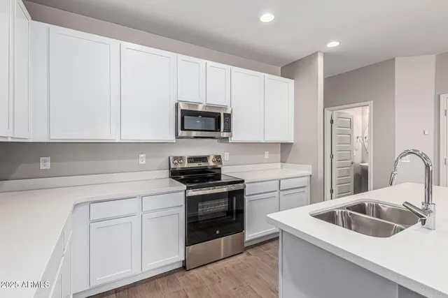 a kitchen with a sink stove top oven and cabinets