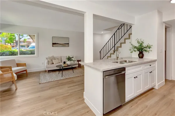 a living room with stainless steel appliances kitchen island granite countertop furniture and a wooden floor