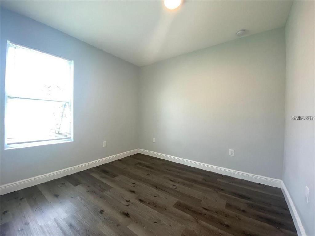 2115 Puffin Street Sebring, FL 33870 - Photo 4 of 9 an empty room with wooden floor and windows