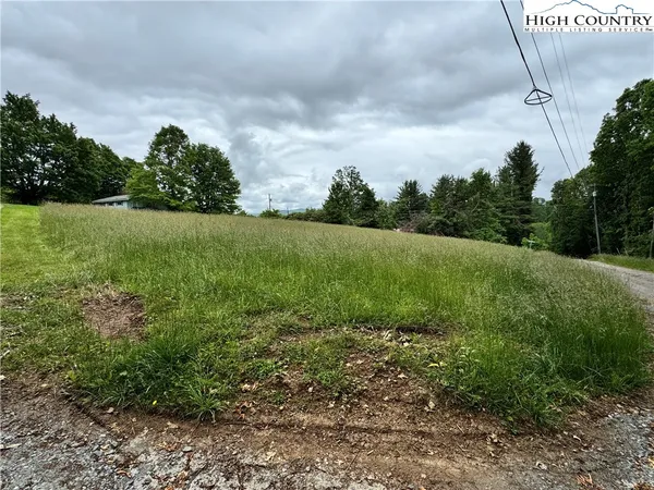 a view of a field with an trees in the background