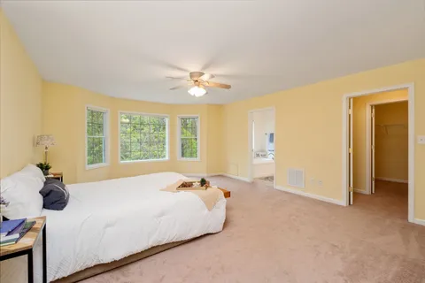 a spacious bedroom with a bed and a chandelier