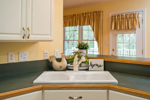 a kitchen with a large window and cabinets