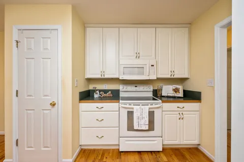 a kitchen with white cabinets and appliances