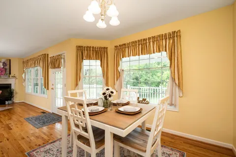 a view of a dining room with furniture a chandelier and wooden floor