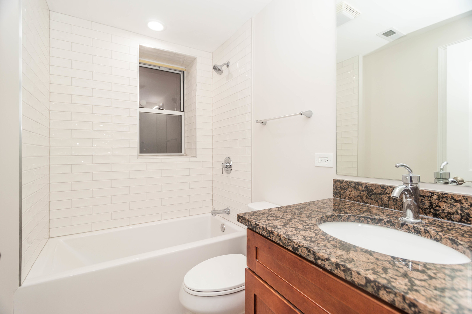 5444 North Winthrop Avenue, Unit GS Chicago, IL 60640 - Photo 17 of 18 a bathroom with a granite countertop toilet a sink and a bathtub