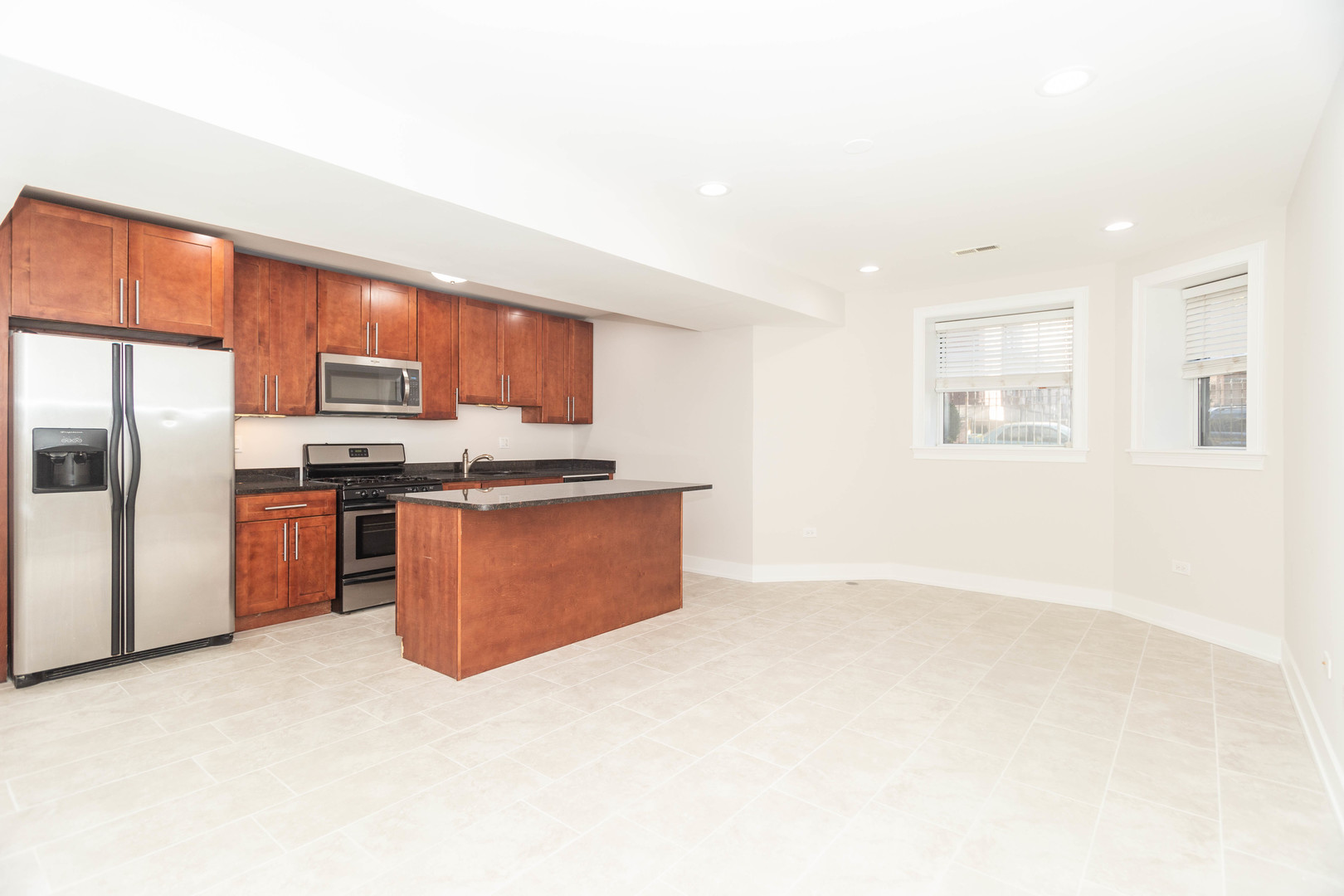 5444 North Winthrop Avenue, Unit GS Chicago, IL 60640 - Photo 3 of 18 a kitchen with stainless steel appliances granite countertop a stove a refrigerator a sink a oven with wooden cabinets