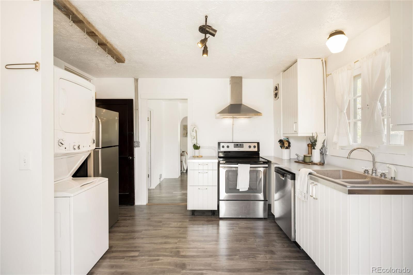 6800 Monaco Street Commerce City, CO 80022 - Photo 11 of 29 a kitchen with a sink cabinets stainless steel appliances and a window