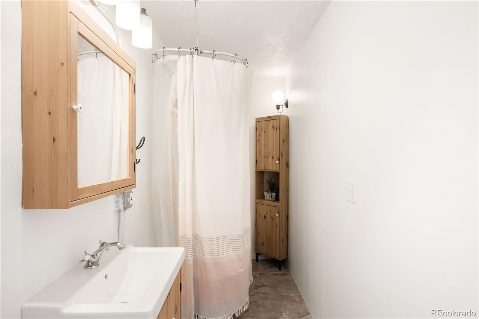 6800 Monaco Street Commerce City, CO 80022 - Photo 13 of 29 a bathroom with a sink and a mirror