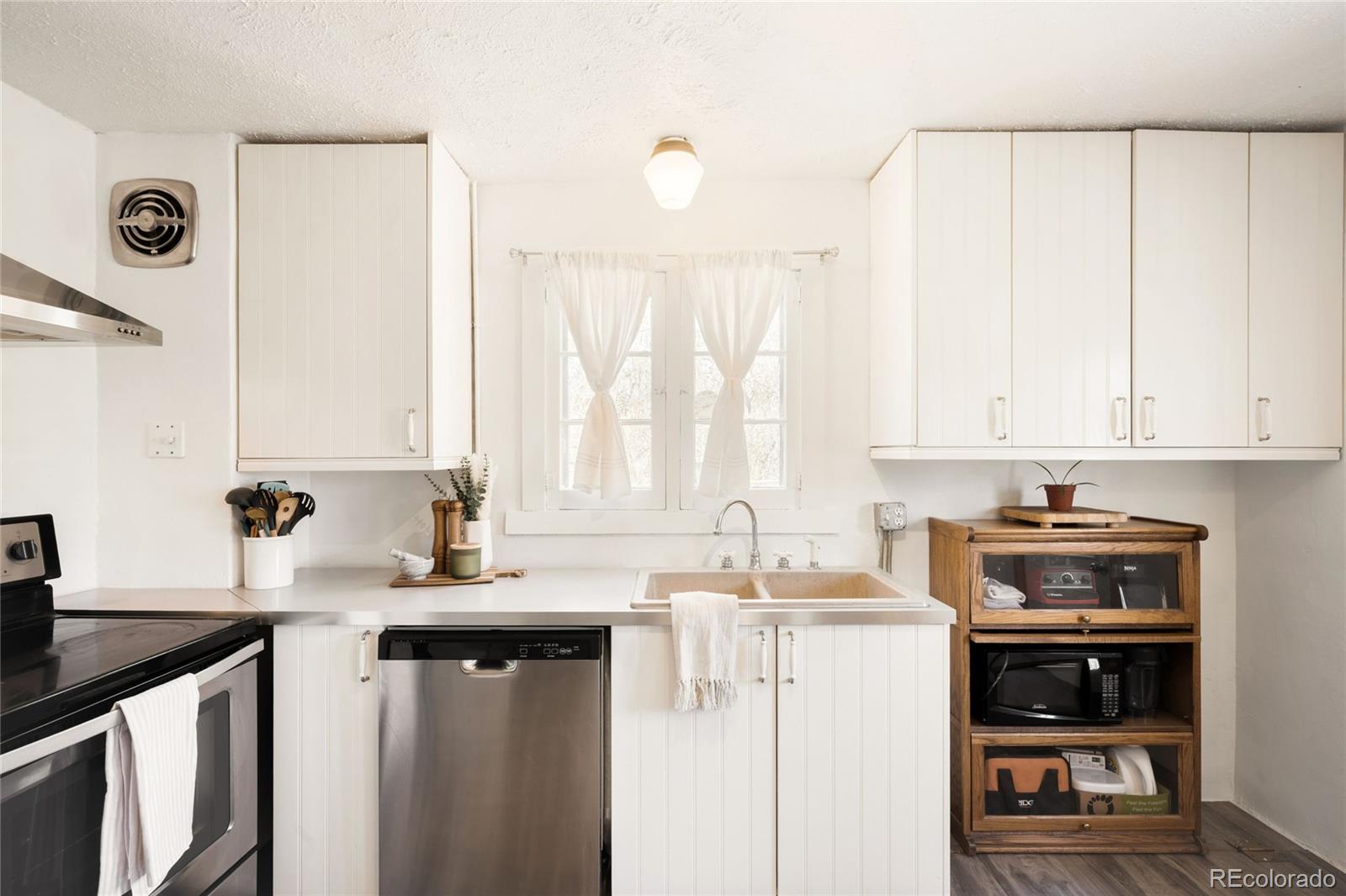 6800 Monaco Street Commerce City, CO 80022 - Photo 9 of 29 a kitchen with stainless steel appliances granite countertop a sink a stove and a refrigerator