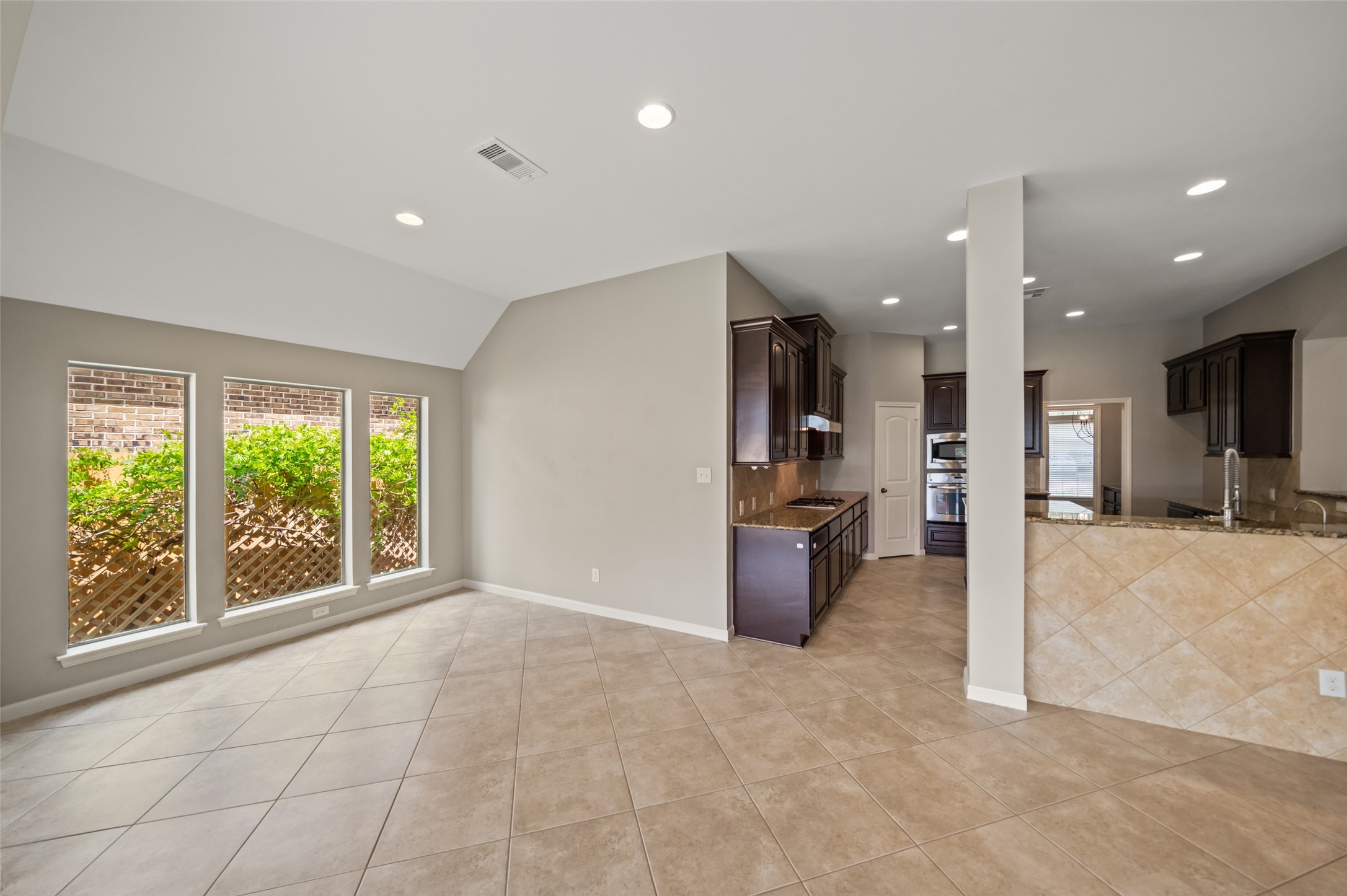 2818 Red Maple Drive Katy, TX 77494 - Photo 24 of 50 a view of a kitchen with a refrigerator a sink wooden cabinets and a couch