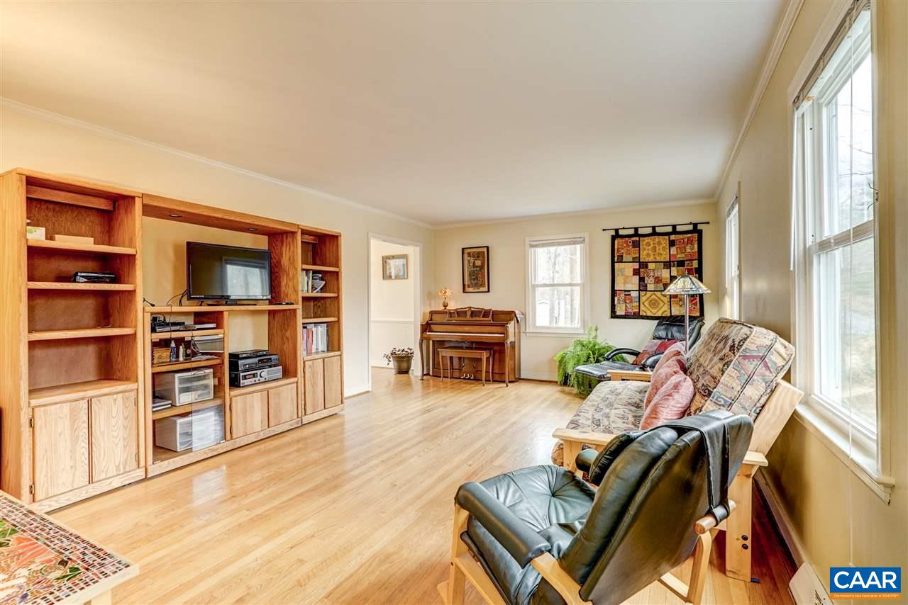 2295 Whippoorwill Road Charlottesville, VA 22901 - Photo 5 of 49 a living room with furniture a bookshelf and a flat screen tv