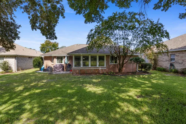 an aerial view of a house with a yard and large tree