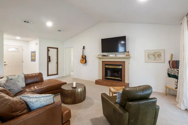 a living room with furniture a flat screen tv and a fireplace