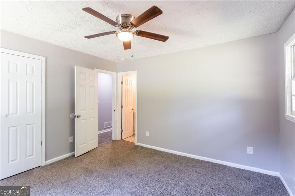 908 East Marable Street Monroe, GA 30656 - Photo 22 of 26 an empty room with a ceiling fan and a window