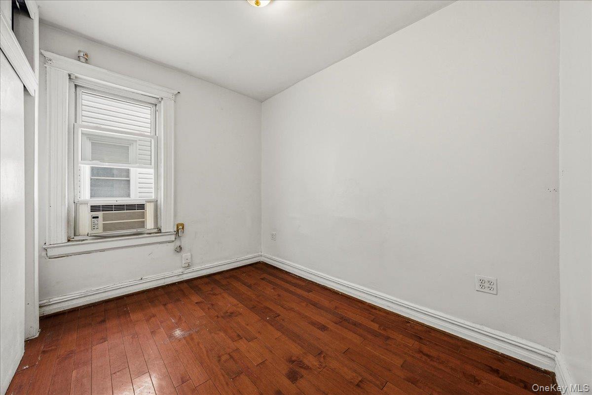 2304 Glebe Avenue Bronx, NY 10462 - Photo 11 of 36 an empty room with wooden floor and windows