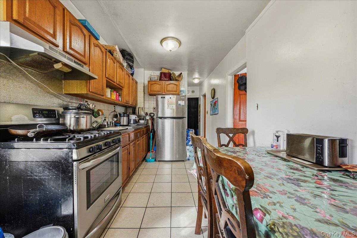 2304 Glebe Avenue Bronx, NY 10462 - Photo 20 of 36 a kitchen with stainless steel appliances granite countertop a stove and a refrigerator