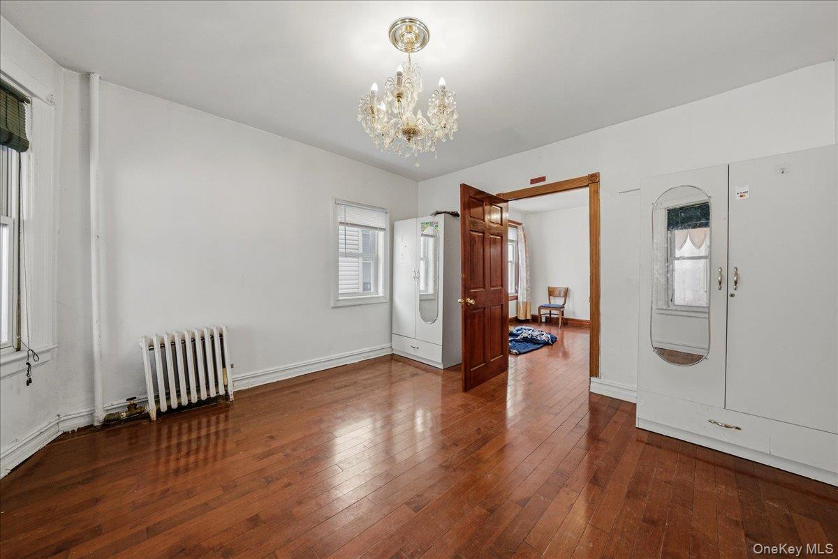 2304 Glebe Avenue Bronx, NY 10462 - Photo 6 of 36 a view of a hallway with wooden floor and a chandelier
