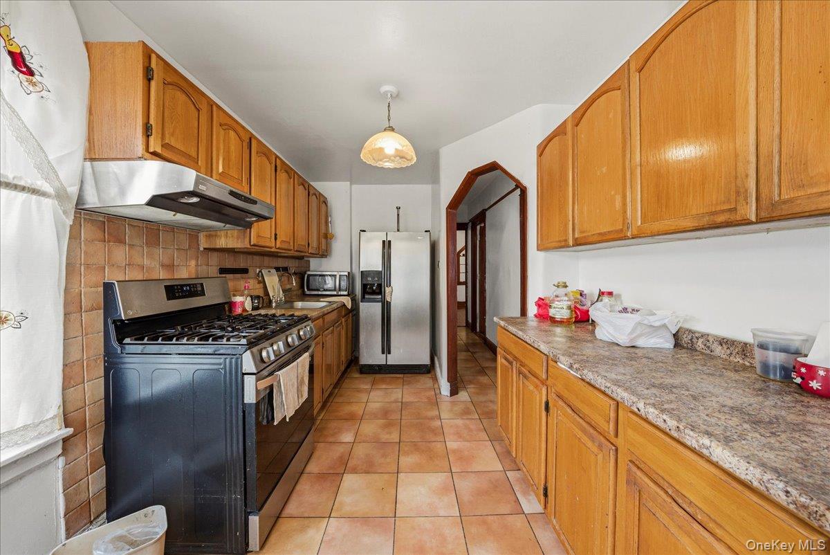 2304 Glebe Avenue Bronx, NY 10462 - Photo 8 of 36 a kitchen with stainless steel appliances granite countertop a stove a sink and a refrigerator