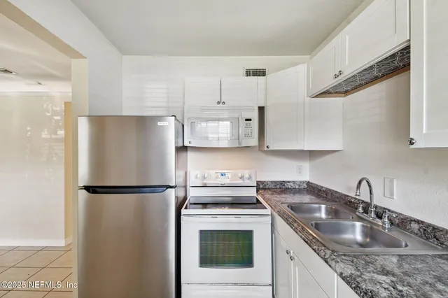 a kitchen with stainless steel appliances granite countertop a refrigerator sink and stove