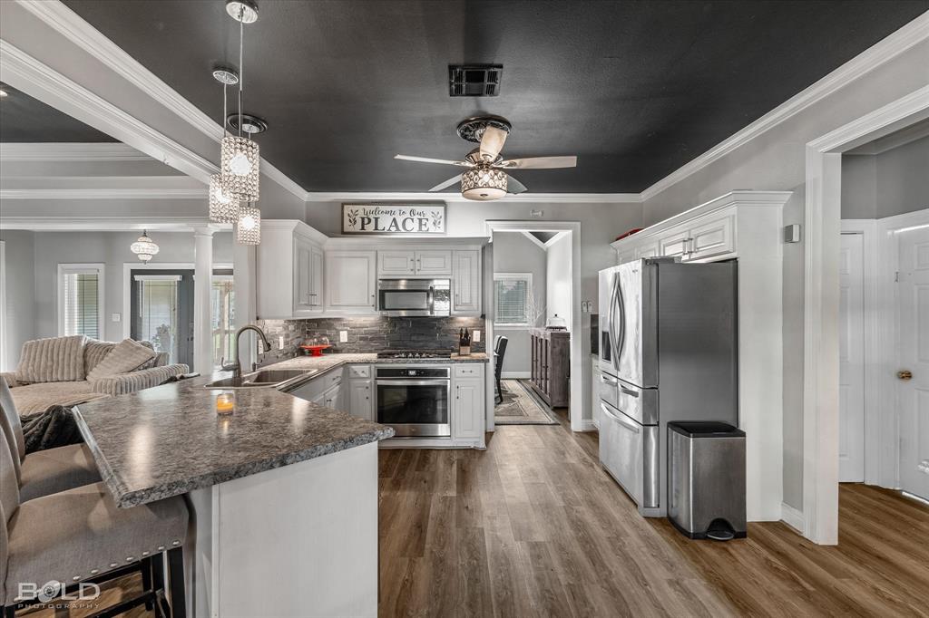 10606 Ferry Lake Road Oil City, LA 71061 - Photo 19 of 38 a kitchen with granite countertop kitchen island stainless steel appliances a stove refrigerator and microwave
