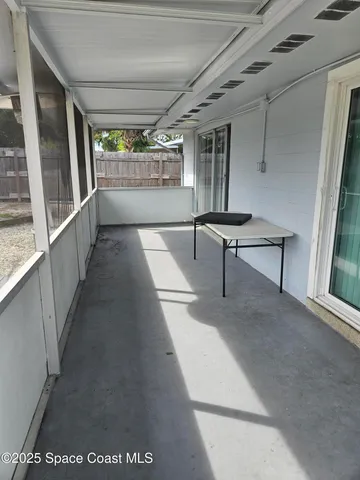 a view of a hallway with wooden floor and furniture