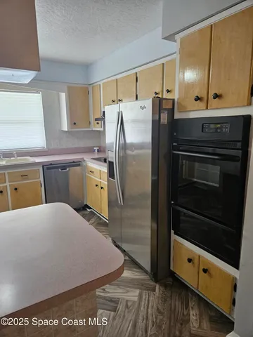 a kitchen with stainless steel appliances a stove a refrigerator and a sink