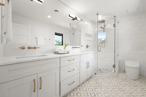 a spacious bathroom with a double vanity sink toilet and shower
