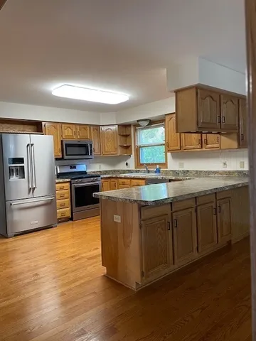 a kitchen with stainless steel appliances granite countertop a stove a sink and a microwave